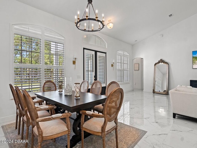 dining space with vaulted ceiling and an inviting chandelier