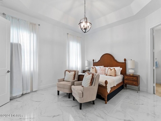 bedroom with a tray ceiling and an inviting chandelier