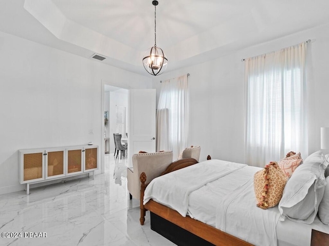 bedroom featuring multiple windows, an inviting chandelier, and a raised ceiling