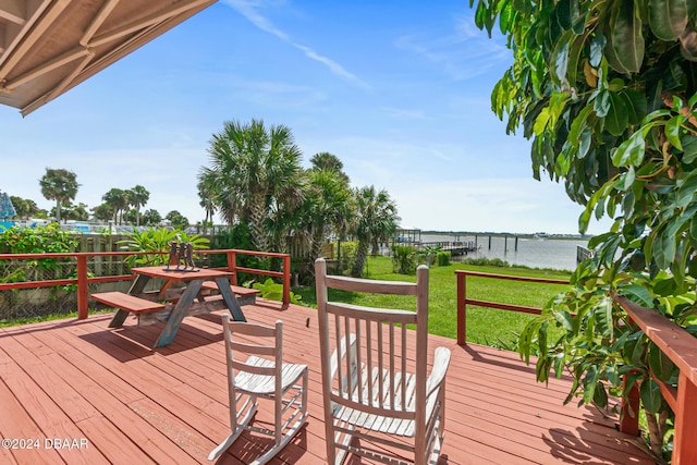 wooden terrace with a yard and a water view