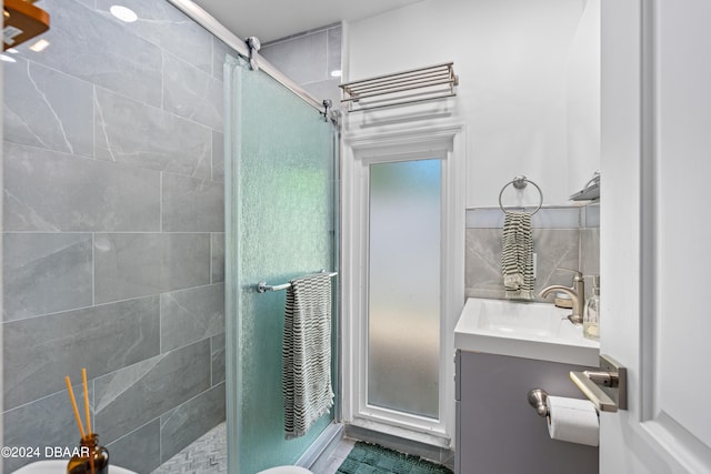 bathroom featuring tile patterned flooring, vanity, backsplash, and a shower with shower door