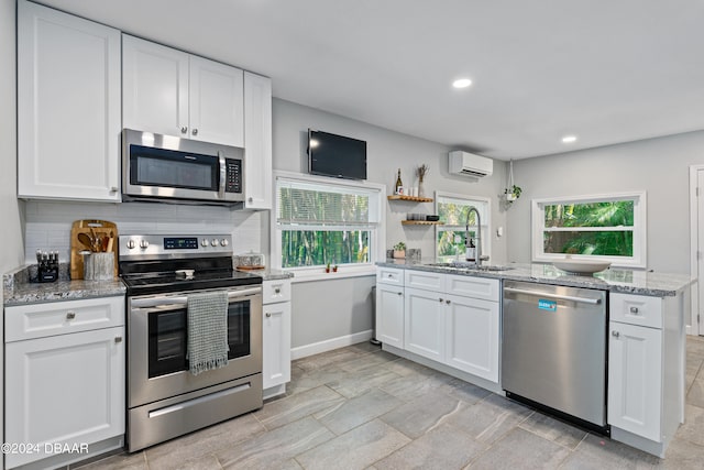 kitchen with stainless steel appliances, white cabinets, and sink