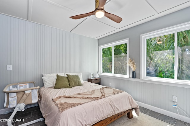 bedroom featuring wood walls and ceiling fan