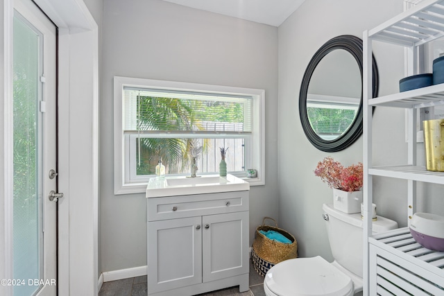 bathroom with toilet, vanity, and tile patterned flooring