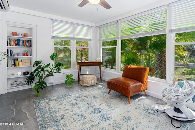 sunroom featuring a wall mounted AC, plenty of natural light, and ceiling fan