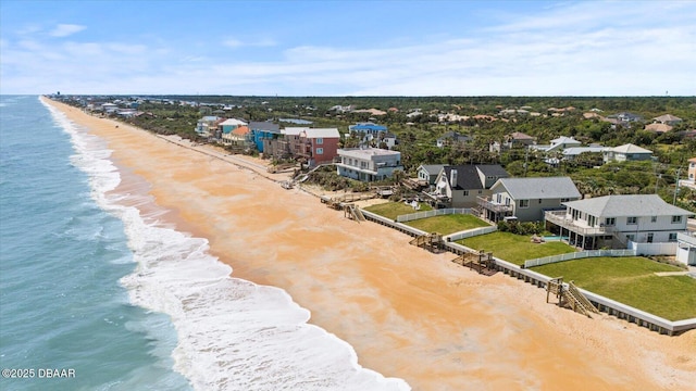 drone / aerial view featuring a beach view and a water view