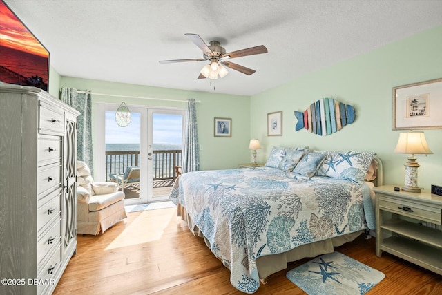 bedroom featuring a textured ceiling, french doors, access to exterior, ceiling fan, and light hardwood / wood-style floors