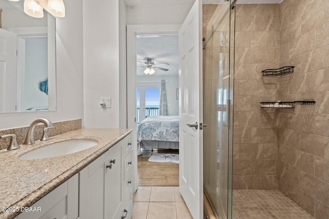 bathroom with ceiling fan, tile patterned floors, walk in shower, and vanity