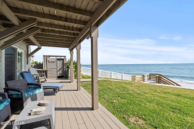 deck featuring a yard, a beach view, and a water view