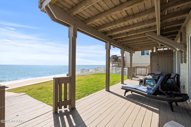 deck with a lawn, a view of the beach, and a water view