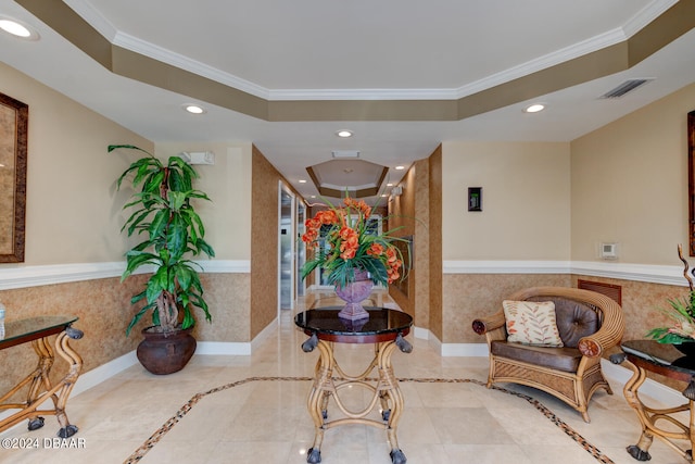 interior space featuring tile patterned floors, crown molding, and a raised ceiling