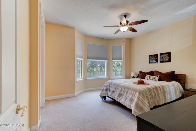 bedroom with a textured ceiling, carpet floors, and ceiling fan