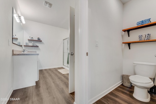 full bath featuring vanity, toilet, baseboards, wood finished floors, and visible vents