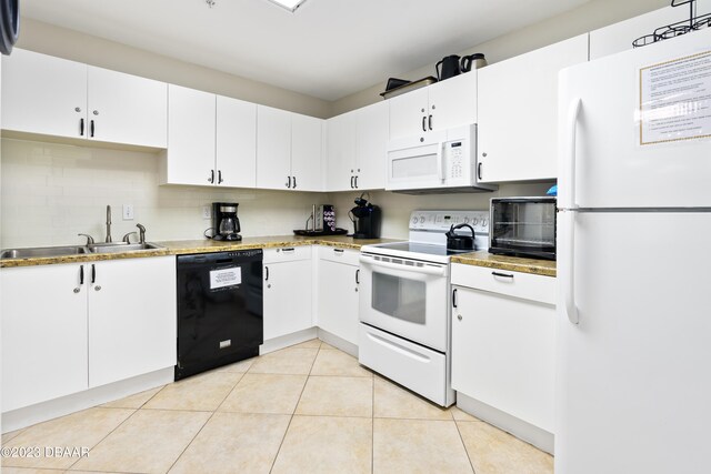 kitchen with decorative backsplash, sink, light tile patterned floors, white cabinetry, and white appliances