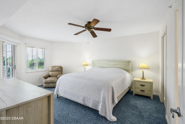 bedroom with dark colored carpet and ceiling fan