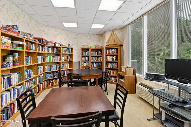 carpeted office featuring a paneled ceiling and a wealth of natural light