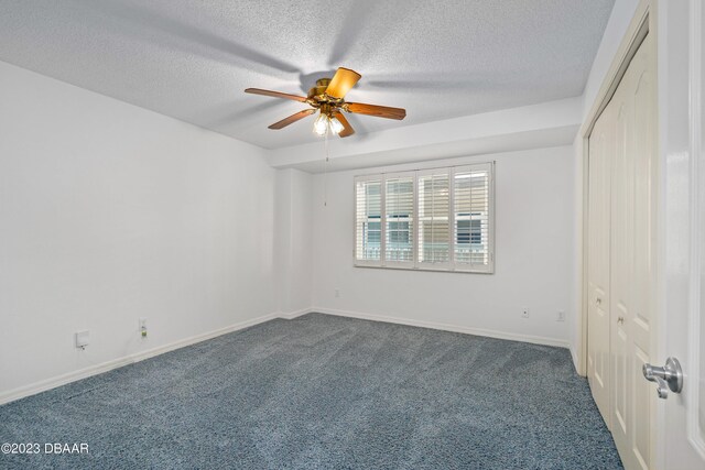 carpeted empty room featuring a textured ceiling and ceiling fan