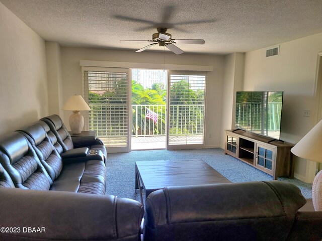 living room with carpet floors, a textured ceiling, and ceiling fan