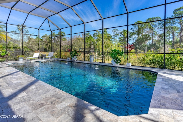 view of swimming pool featuring glass enclosure and a patio area