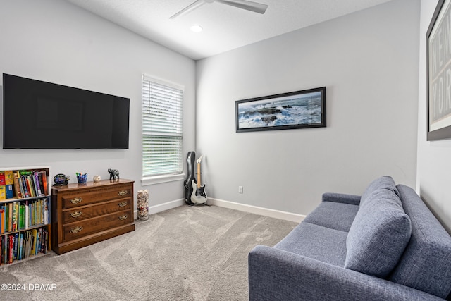 sitting room with ceiling fan and carpet