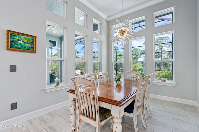 dining room featuring crown molding, light hardwood / wood-style floors, and a notable chandelier