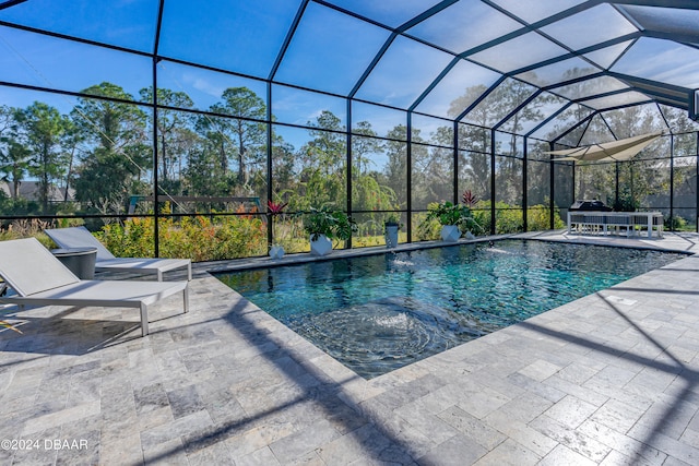 view of pool featuring pool water feature, glass enclosure, and a patio