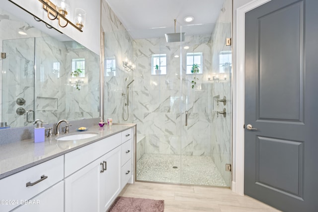 bathroom featuring hardwood / wood-style floors, vanity, and a shower with door