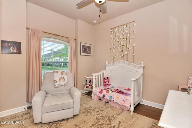 bedroom featuring ceiling fan, baseboards, and wood finished floors