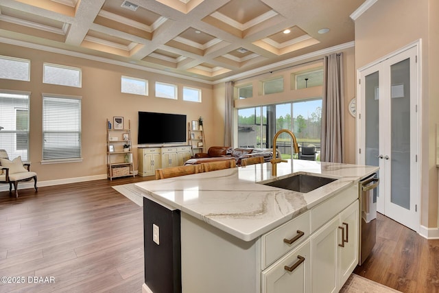 kitchen with open floor plan, french doors, a high ceiling, wood finished floors, and a sink