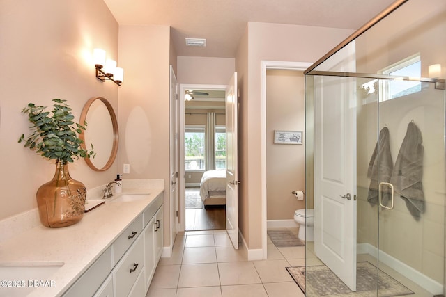 ensuite bathroom with visible vents, double vanity, a stall shower, a sink, and tile patterned floors