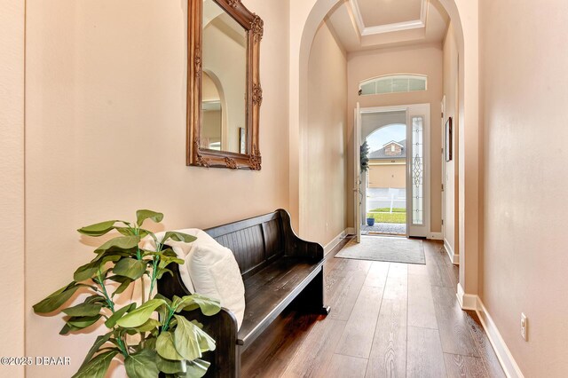 entryway featuring crown molding, baseboards, and hardwood / wood-style flooring