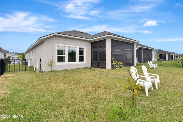 rear view of property with stucco siding, a lawn, a fenced backyard, and a sunroom