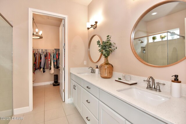 bathroom with tile patterned flooring, a shower stall, double vanity, and a sink