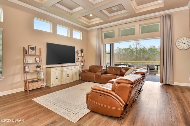 living area with wood finished floors, coffered ceiling, a towering ceiling, crown molding, and beamed ceiling