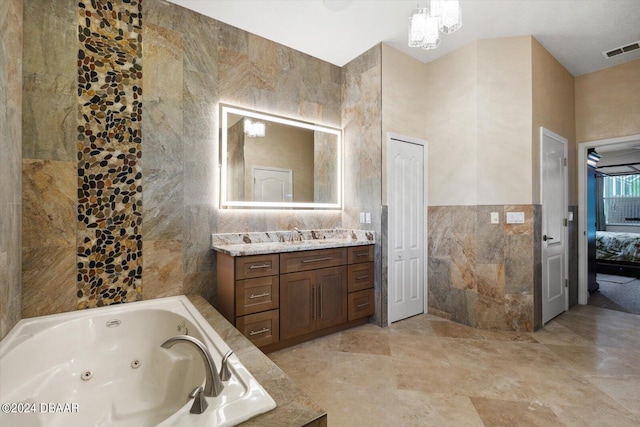 bathroom with a tub to relax in, tile walls, and vanity