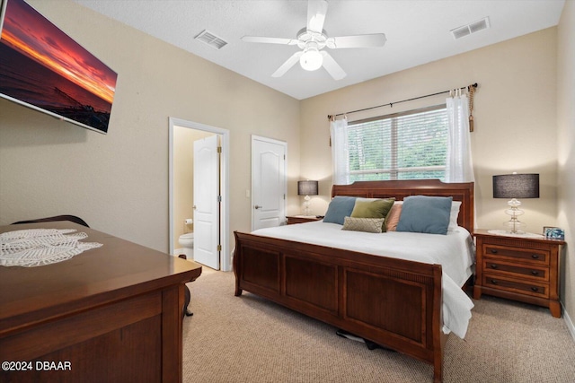 carpeted bedroom featuring ceiling fan and ensuite bath