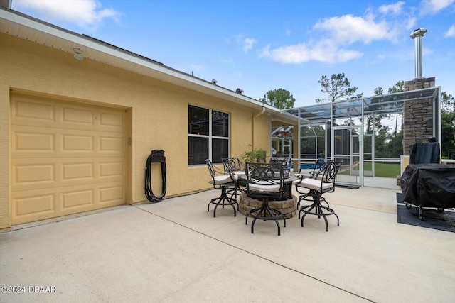 view of patio with area for grilling and glass enclosure