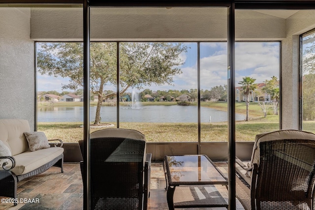 sunroom / solarium featuring a healthy amount of sunlight and a water view