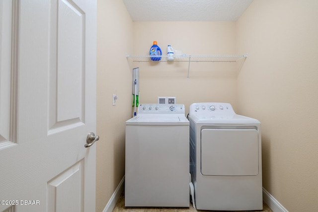 laundry room with a textured ceiling and separate washer and dryer