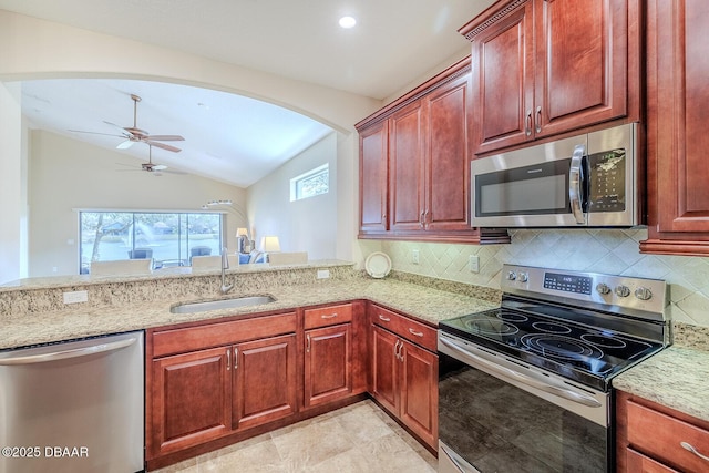 kitchen featuring appliances with stainless steel finishes, kitchen peninsula, light stone countertops, sink, and lofted ceiling