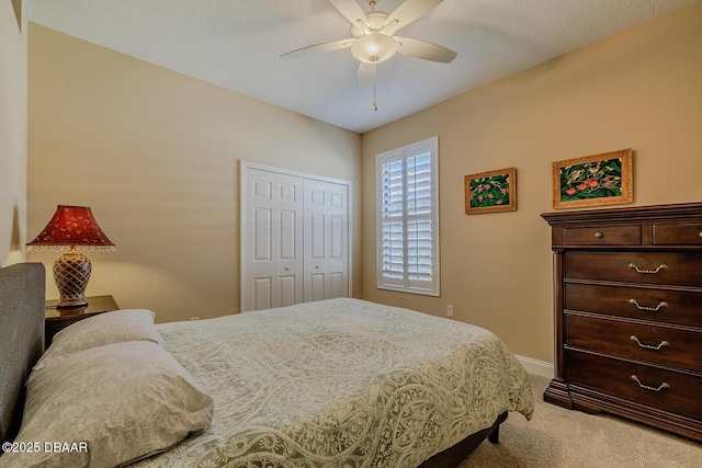 carpeted bedroom featuring ceiling fan and a closet