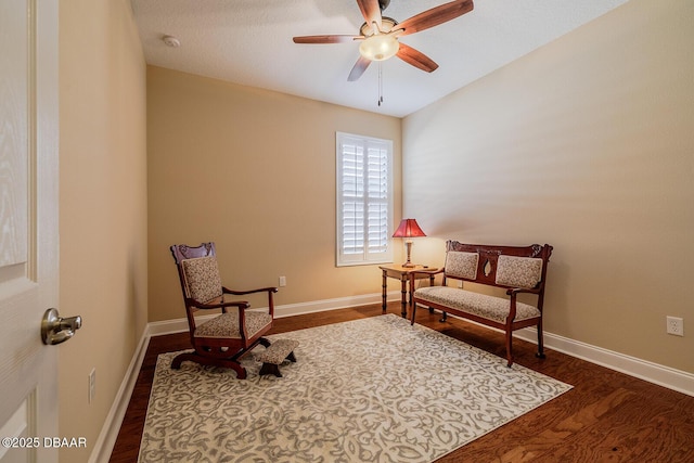 sitting room featuring dark wood-type flooring and ceiling fan