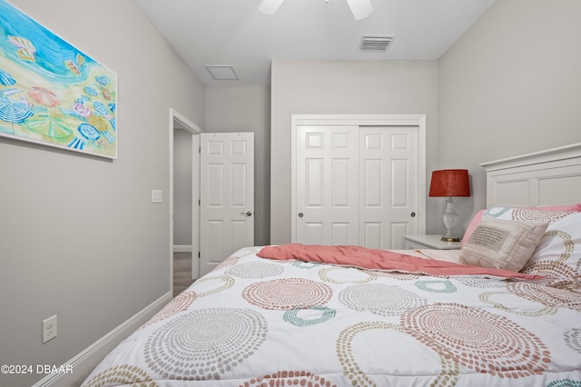 bedroom featuring hardwood / wood-style flooring, ceiling fan, and a closet