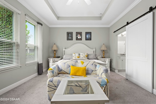 bedroom with connected bathroom, a barn door, light carpet, and ceiling fan