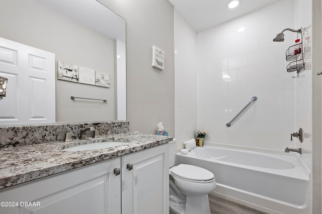 full bathroom featuring tiled shower / bath combo, vanity, hardwood / wood-style flooring, and toilet