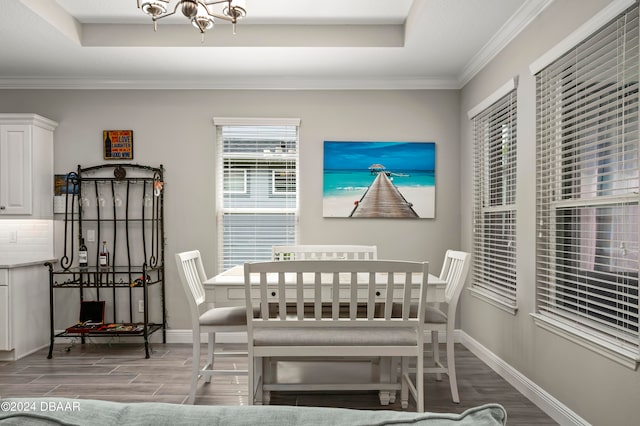 dining area featuring a raised ceiling, light hardwood / wood-style floors, and crown molding