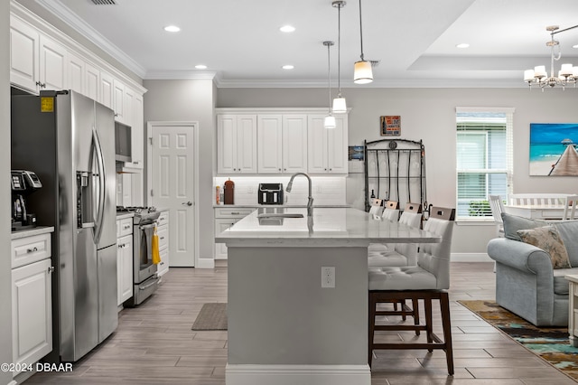 kitchen featuring white cabinetry, sink, a kitchen island with sink, and appliances with stainless steel finishes