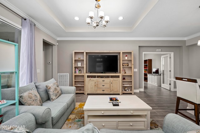 living room featuring ornamental molding, dark hardwood / wood-style flooring, a tray ceiling, and an inviting chandelier