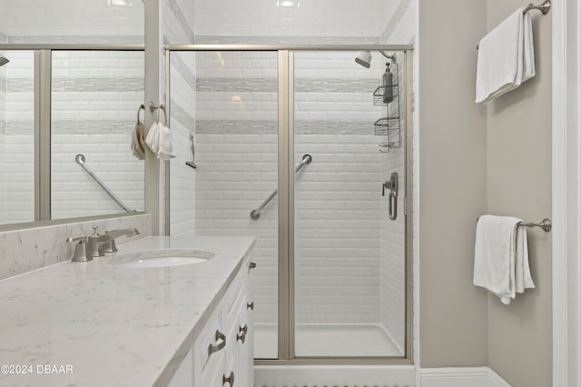 bathroom with vanity and a shower with door