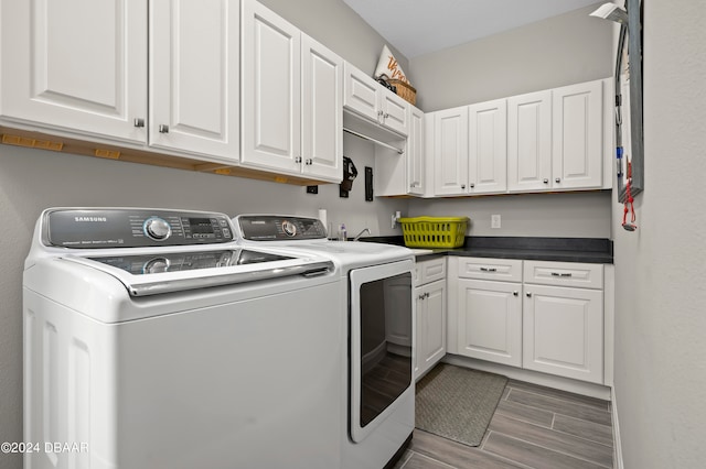 washroom with dark hardwood / wood-style flooring, cabinets, and washing machine and clothes dryer